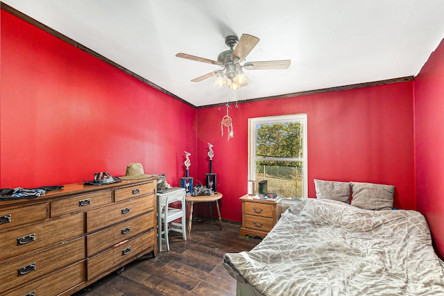 bedroom featuring dark hardwood / wood-style flooring, ceiling fan, and ornamental molding