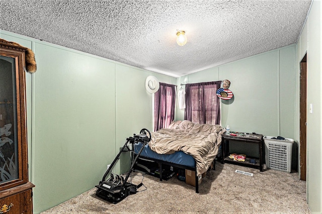 bedroom with a textured ceiling and light carpet