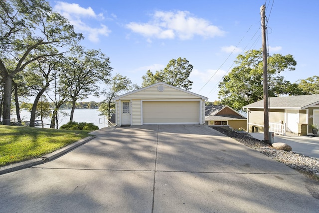 view of front of house featuring an outbuilding, a water view, a garage, and a front yard