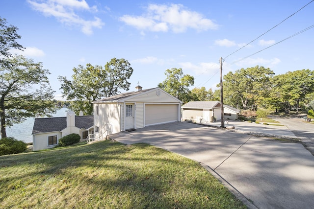 view of front of home with an outdoor structure, a front yard, and a garage