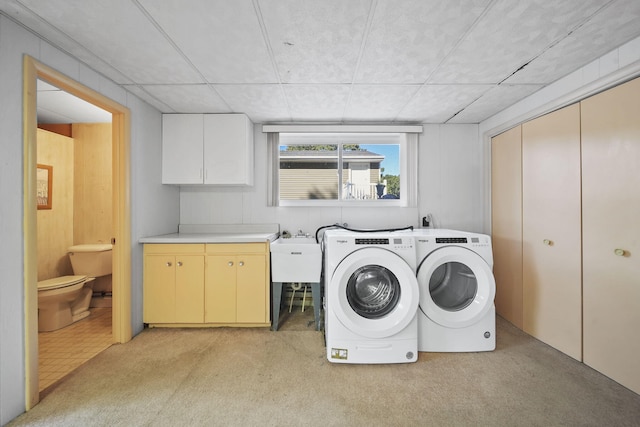 washroom with light carpet, washer and clothes dryer, cabinets, and sink