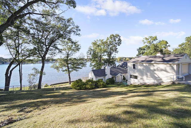 view of yard featuring a water view and a garage