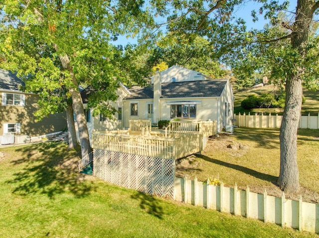 rear view of property featuring a deck and a lawn