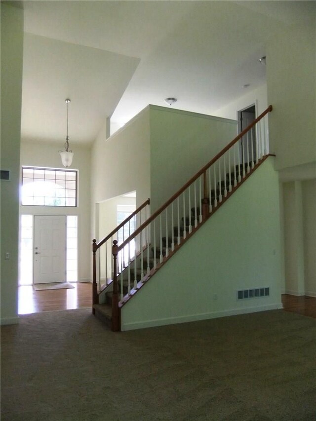 48945 Tuscan Hls, Plymouth, MI 48170 - carpeted foyer with stairway, a chandelier, a towering ceiling, and baseboards
