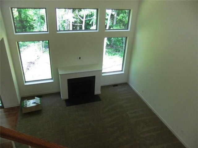 48945 Tuscan Hls, Plymouth, MI 48170 - unfurnished living room with plenty of natural light, a fireplace with flush hearth, and baseboards