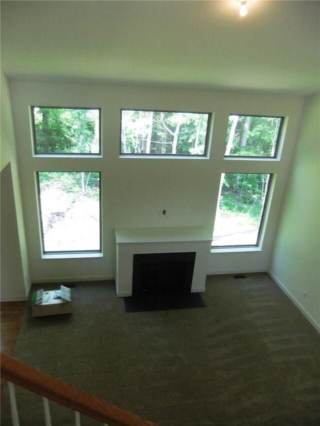 48945 Tuscan Hls, Plymouth, MI 48170 - unfurnished living room with plenty of natural light, a fireplace with flush hearth, and baseboards