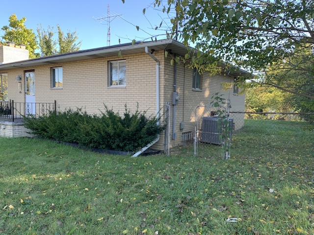 view of home's exterior with a lawn and central AC