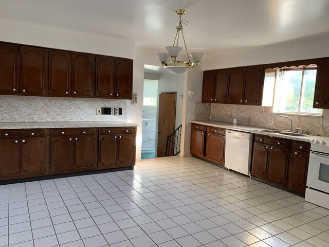 kitchen featuring sink, hanging light fixtures, a notable chandelier, white appliances, and dark brown cabinets