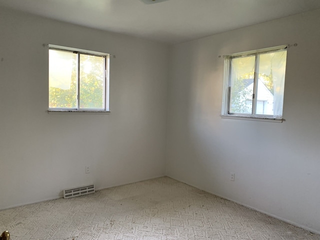 unfurnished room featuring light carpet