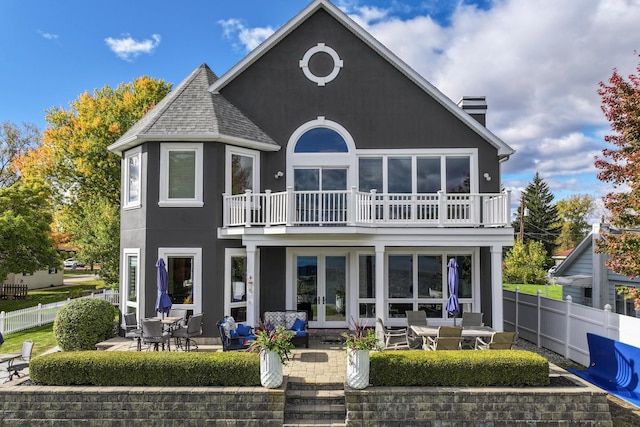 back of property with french doors, a balcony, and a patio area