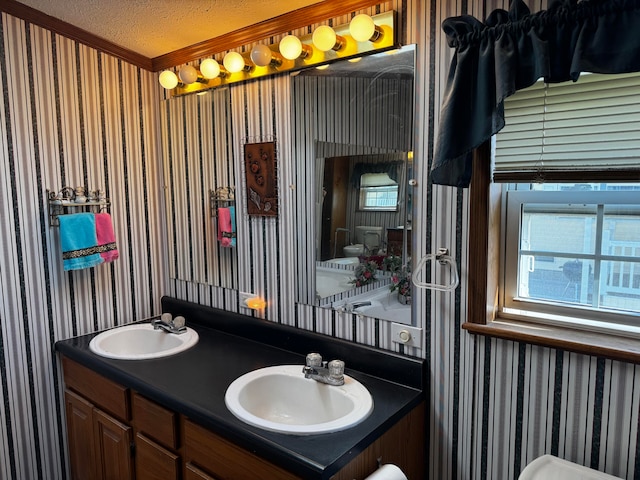 bathroom with vanity, a textured ceiling, and crown molding