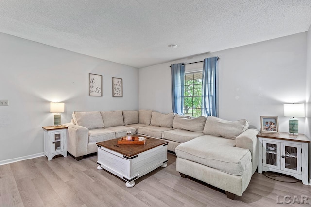 living room with a textured ceiling and light wood-type flooring