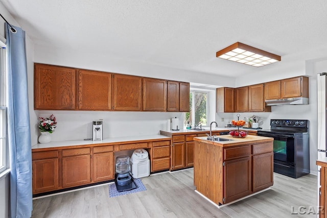 kitchen featuring a kitchen island with sink, sink, a textured ceiling, black / electric stove, and light hardwood / wood-style floors