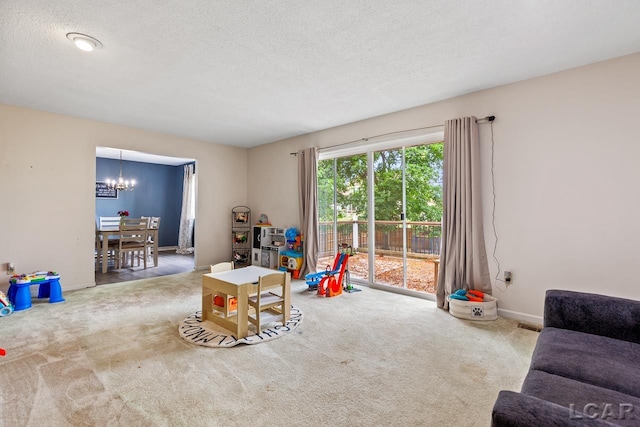 rec room featuring carpet floors, a textured ceiling, and a notable chandelier