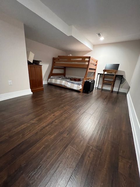 unfurnished bedroom with dark hardwood / wood-style flooring