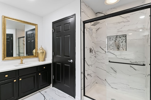 bathroom featuring a shower with door and vanity