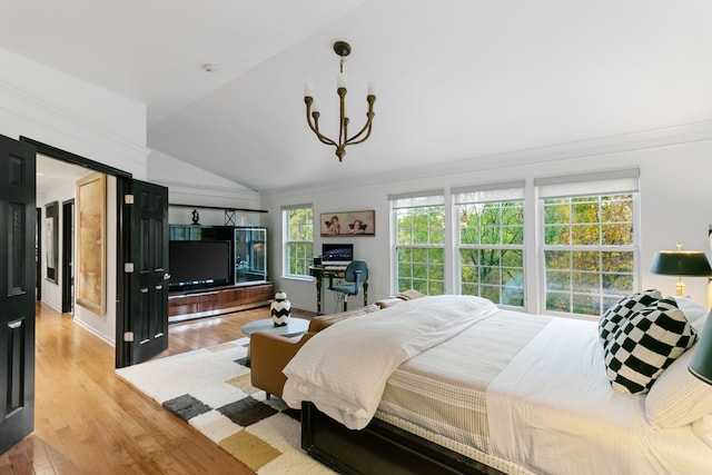 bedroom with light hardwood / wood-style floors, lofted ceiling, and a chandelier