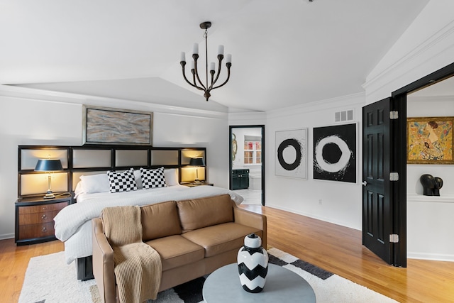 bedroom with a chandelier, light wood-type flooring, ensuite bathroom, and vaulted ceiling