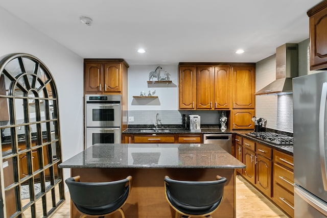 kitchen featuring a center island, wall chimney exhaust hood, tasteful backsplash, dark stone counters, and appliances with stainless steel finishes