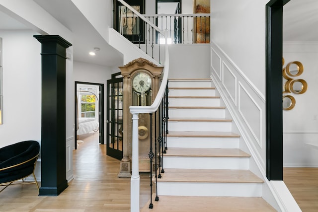 stairs with hardwood / wood-style flooring and ornamental molding