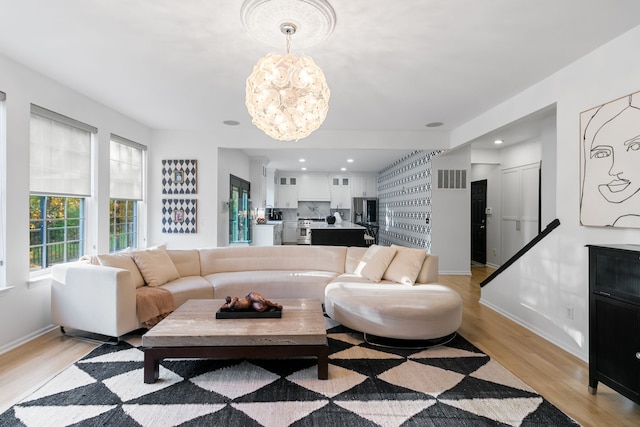 living room featuring light hardwood / wood-style floors and an inviting chandelier