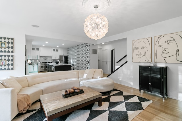 living room featuring light wood-type flooring and an inviting chandelier