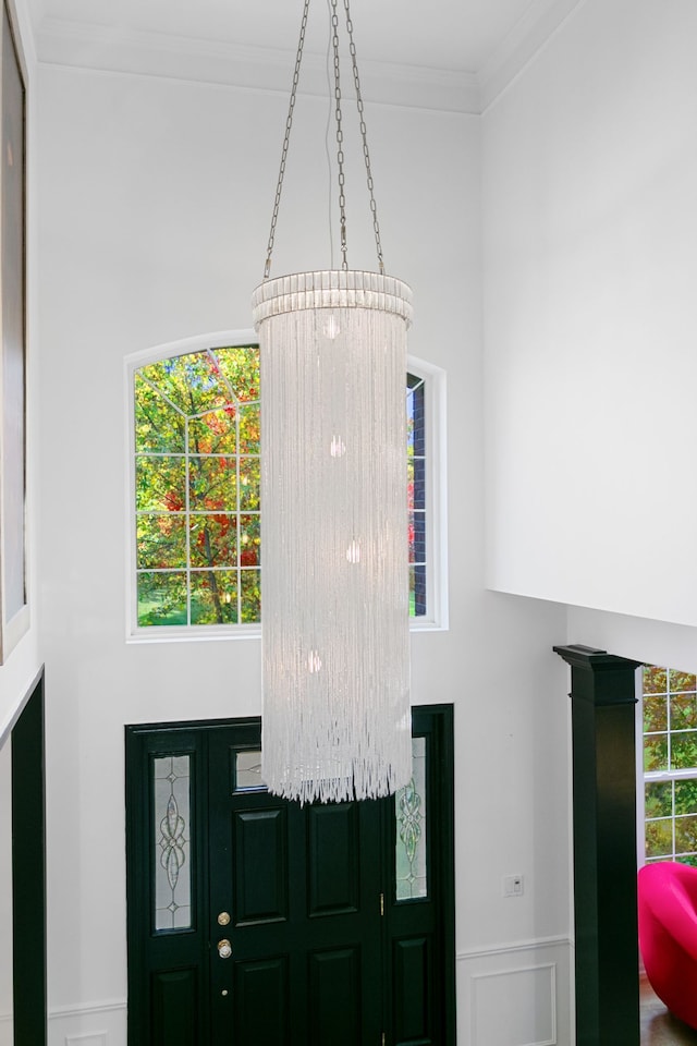 foyer entrance with an inviting chandelier and crown molding