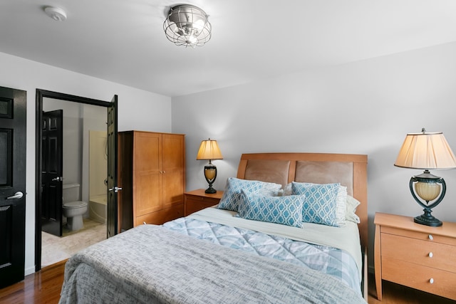 bedroom featuring wood-type flooring and ensuite bath