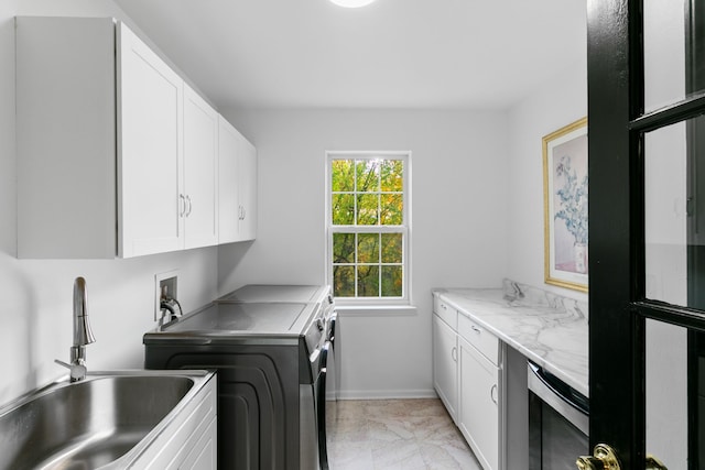 laundry room with cabinets, washing machine and dryer, beverage cooler, and sink