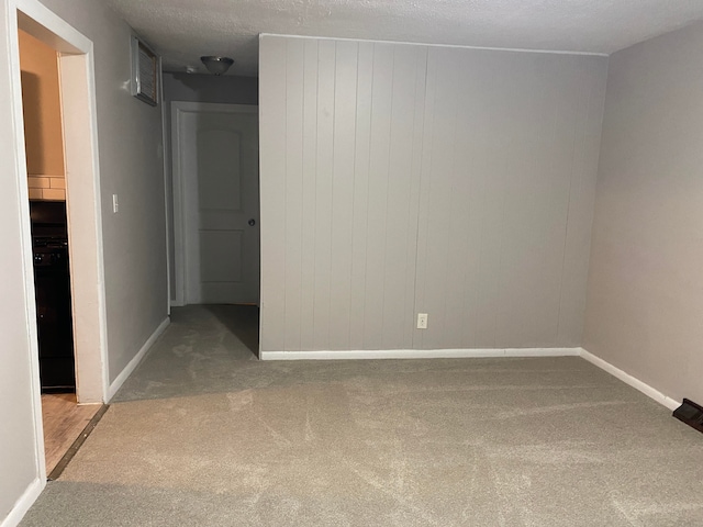 carpeted empty room with a textured ceiling