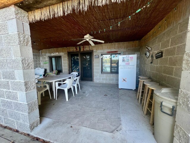 view of patio featuring ceiling fan and an outdoor bar