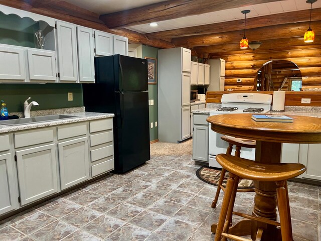 kitchen featuring pendant lighting, sink, white gas range, rustic walls, and beamed ceiling