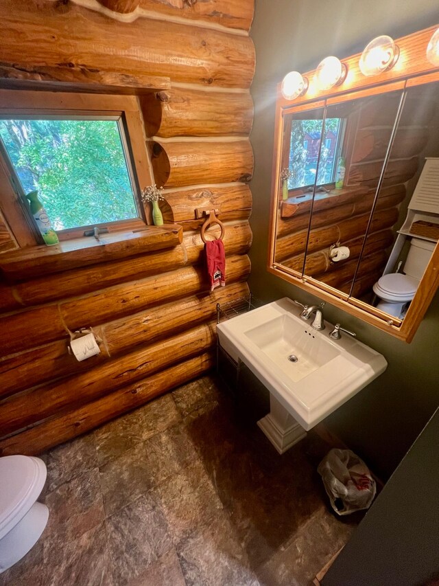 bathroom featuring toilet and rustic walls