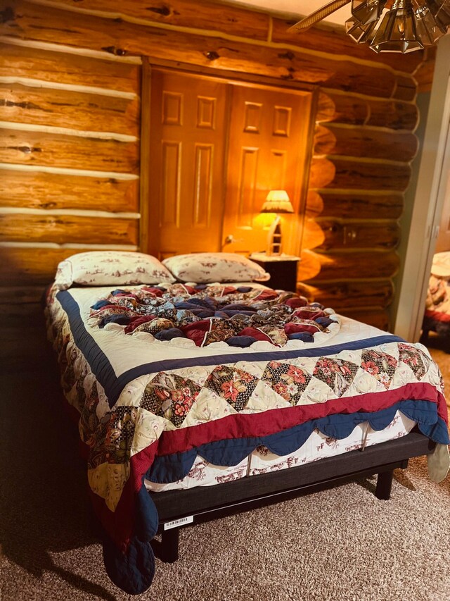 bedroom featuring carpet floors and log walls