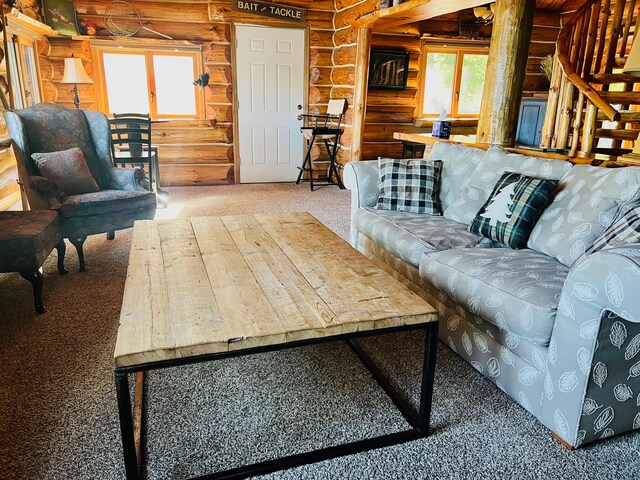 living room featuring carpet flooring, a healthy amount of sunlight, and log walls