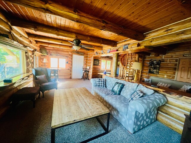 living room featuring carpet, wooden ceiling, ceiling fan, log walls, and beamed ceiling