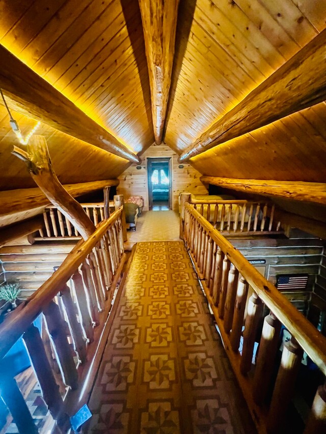 hallway featuring wood ceiling, log walls, and lofted ceiling with beams