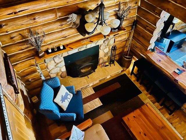 living room featuring rustic walls, wood-type flooring, and a notable chandelier