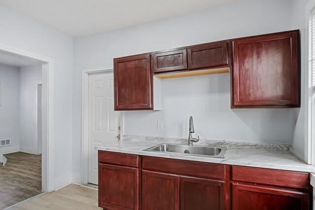5015 Vancouver St, Detroit, MI 48204 - kitchen with a sink, dark brown cabinets, light countertops, and light wood-style floors