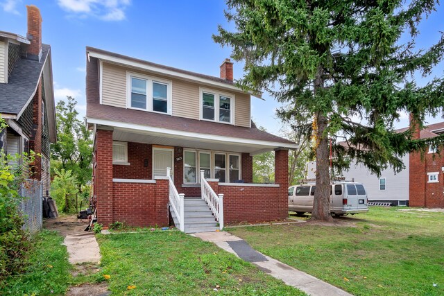 5015 Vancouver St, Detroit, MI 48204 - american foursquare style home featuring a chimney, covered porch, brick siding, and a front lawn