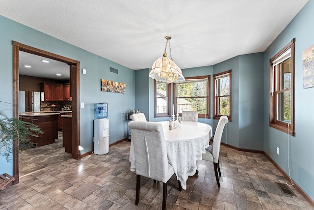 dining room featuring a textured ceiling and an inviting chandelier