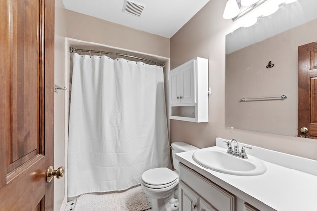 bathroom with vanity, toilet, and walk in shower