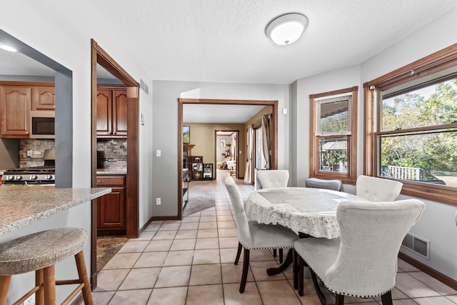 dining space featuring light tile patterned floors and a textured ceiling