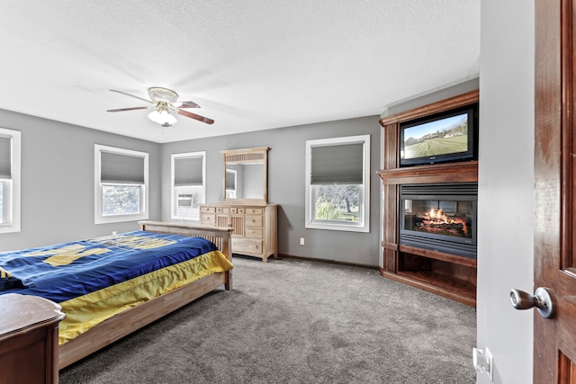 bedroom with carpet flooring, ceiling fan, a textured ceiling, and multiple windows