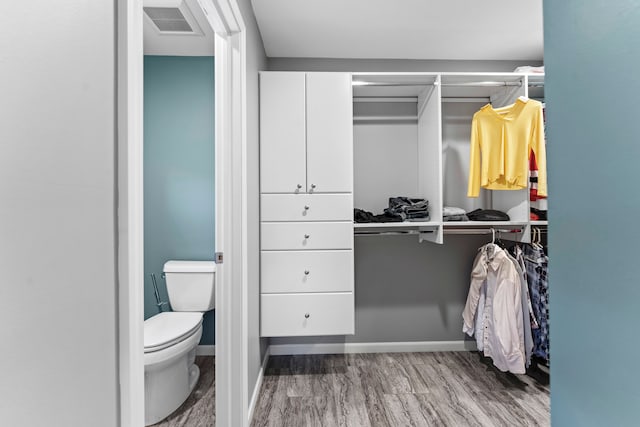 interior space with hardwood / wood-style floors and toilet