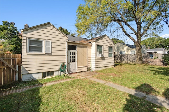 view of front of home with cooling unit and a front yard