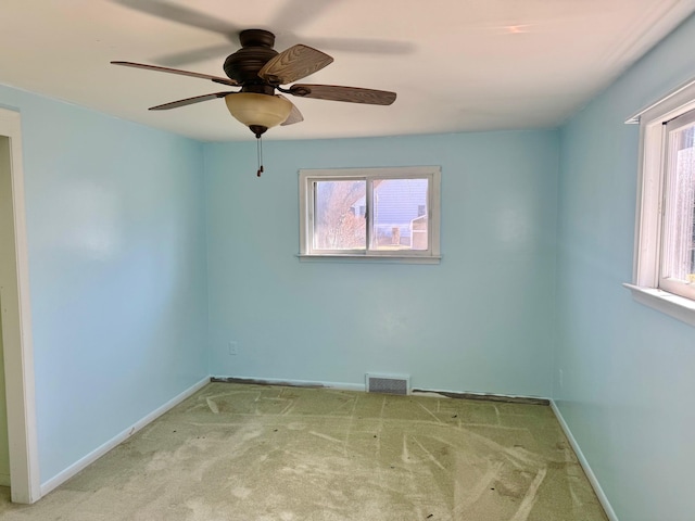 carpeted spare room featuring visible vents, plenty of natural light, and baseboards