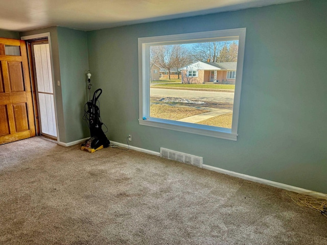 spare room with visible vents, baseboards, and carpet