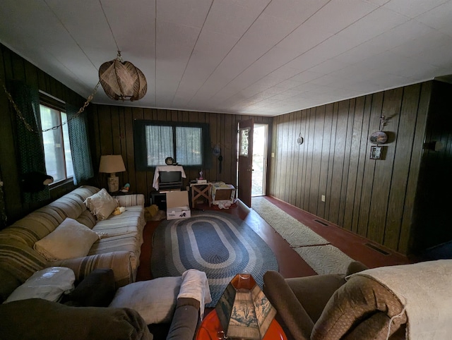 carpeted living room featuring a wealth of natural light and wooden walls