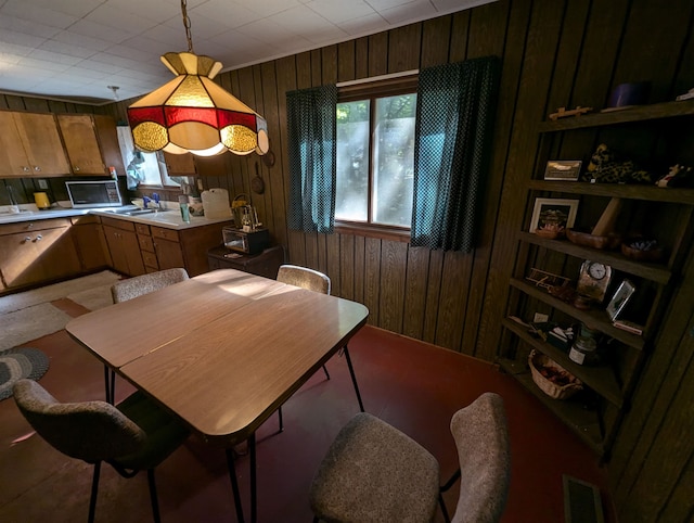 carpeted dining room with wooden walls and sink